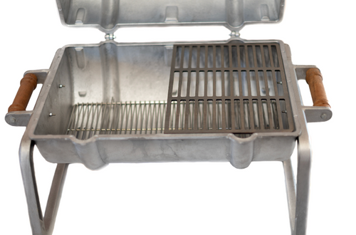 A small aluminum portable grill with a hinged lid, metal grate, and brown handles, shown against a white background with black letterboxing above and below.