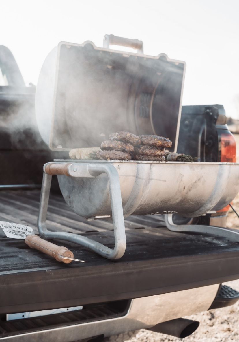 Grill running on the open tailgate of a pickup